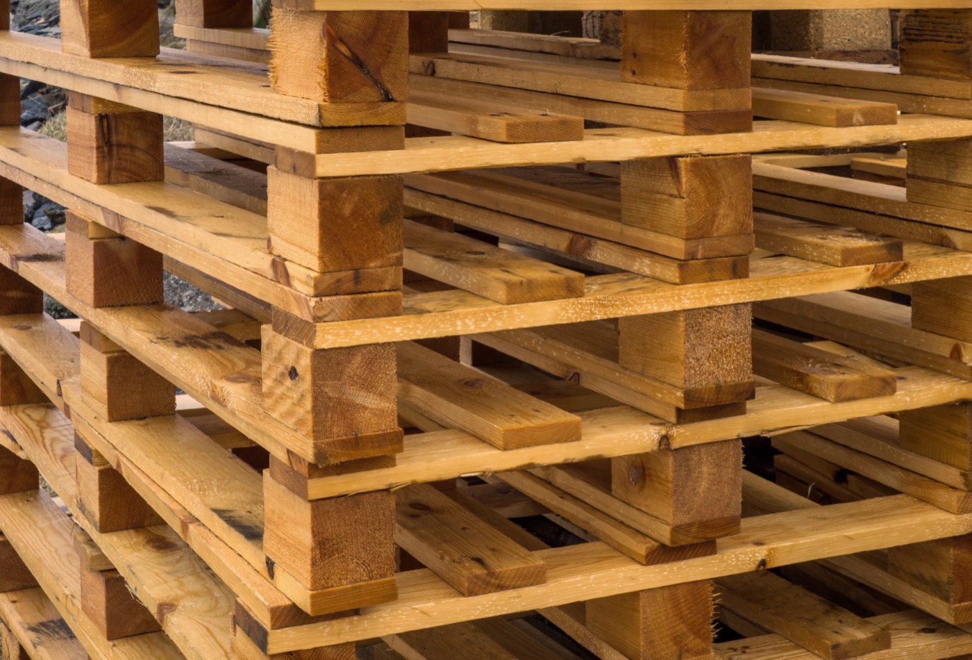 Close-up of wooden pallets stacked in layers, showing the blocks and slats of each pallet